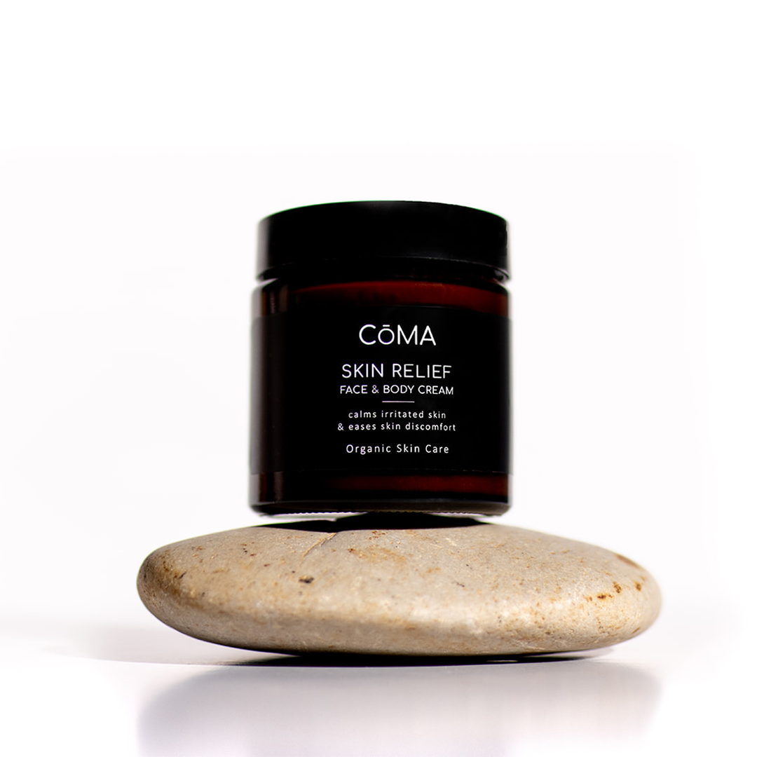 CÔMA Skin Relief face & body cream jar on a stone for soothing irritated skin and skin discomfort.